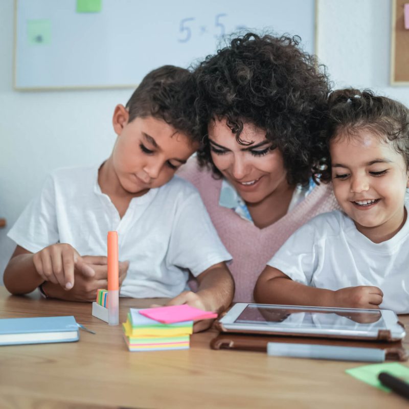 teacher-using-tablet-with-children-in-kindergarten-school-focus-on-girl-face.jpg